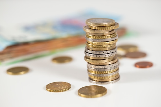 Euro coins in column on table in white environment