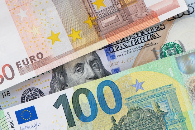 Euro en dollarbiljetten euro tegen dollar Een nadere blik van de president van de VS met een dollarbiljet dat van achter een eurobiljet gluurt De financiële relatie van de VS en Europa Close-up bovenaanzicht