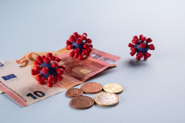 euro money, coins and models of covid-19 virus
contaminated infected cash money. economy crisis
