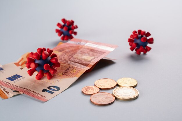 euro money, coins and models of covid-19 virus
contaminated infected cash money. economy crisis
