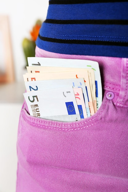 Foto euro denaro in tasca pantaloni viola su sfondo sfocato primo piano