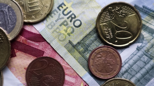 Foto eurobankbiljetten en munten als achtergrond. schot kijken naar de euro. munten worden in verschillende posities op elkaar gestapeld. geld concept.