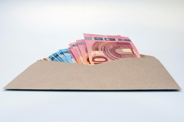 Foto eurobankbiljetten in bruine envelop. open envelop met geldbankbiljetten op tafel. envelop met euro-geldbiljetten