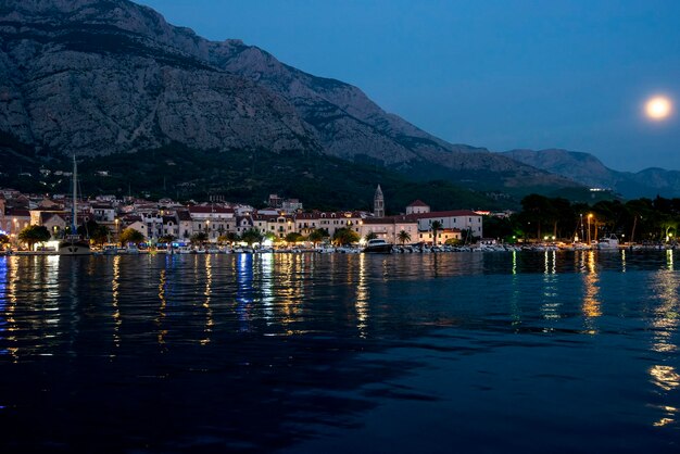 Europa. Kroatië. Panorama van de oude binnenstad van Makarska en de stad 's nachts