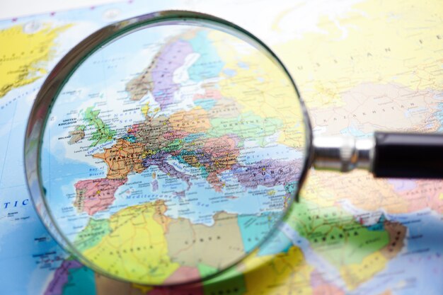 Photo europe : magnifying glass on world map background.