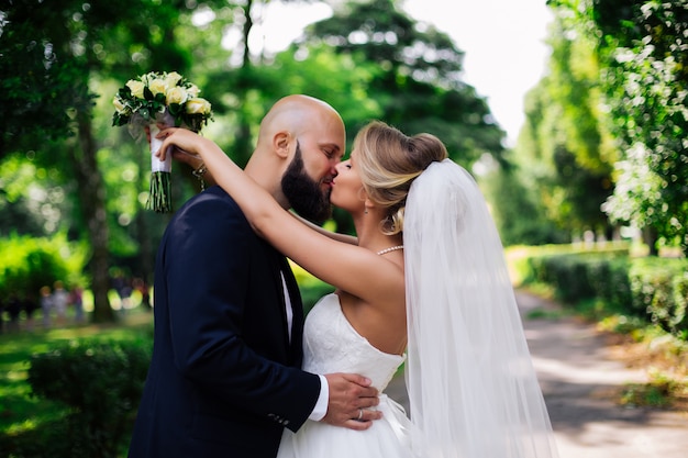 European bride and groom kissing in the park