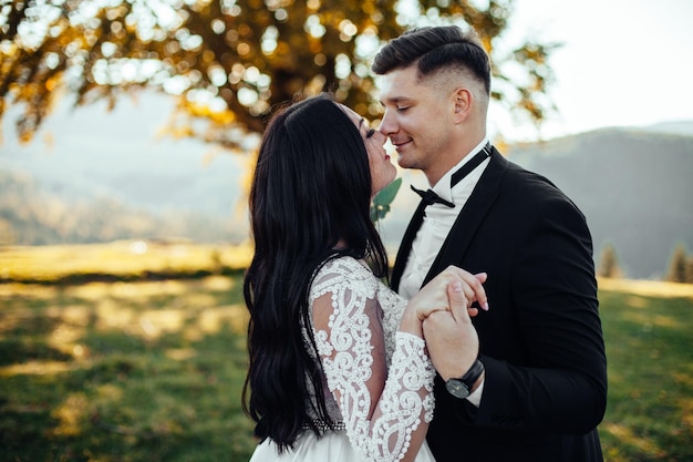 Foto sposa e sposo europei che baciano nel parco