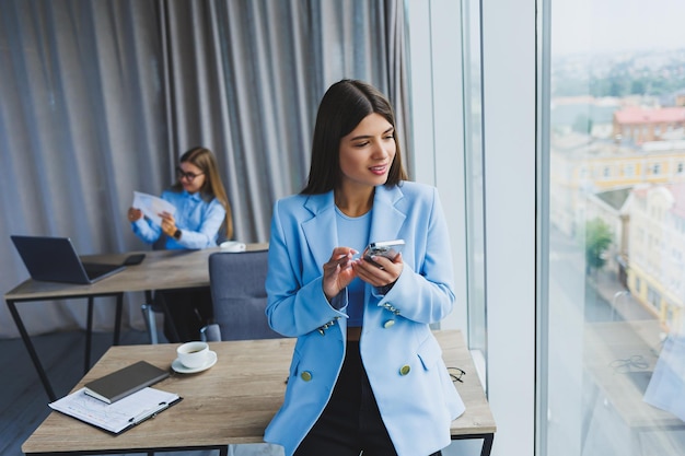 European businesswoman while working in the office Young serious Millennial brunette woman in a jacket The concept of freelance and remote work Modern women's lifestyle