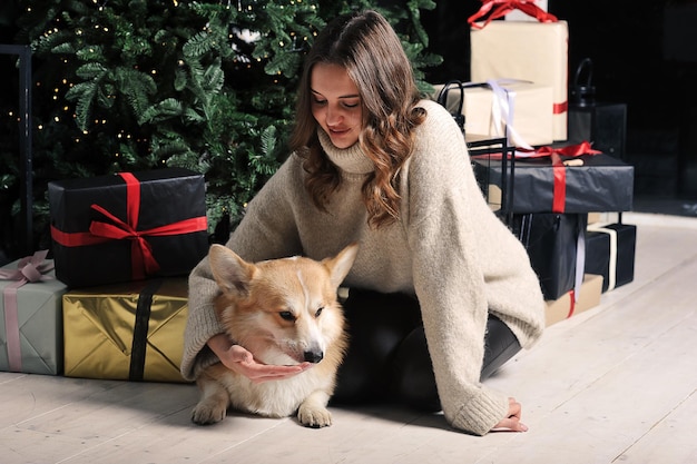 European caucasian young woman is sitting under a Christmas tree