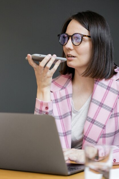 European confident business woman in a pink jacket and with a laptop in her office working