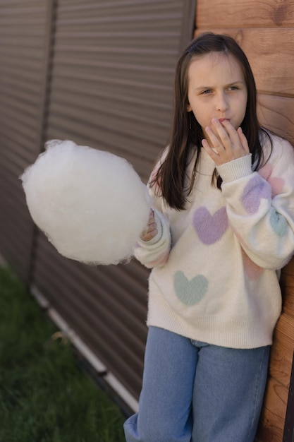 European girl eating cotton candy in the park