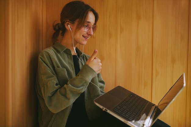 European girl using a laptop communicates with friends in an online chat vintage photo processing