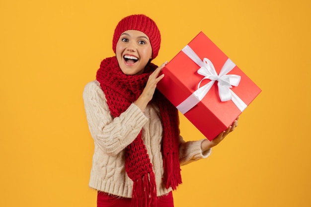 European lady in knit hat with christmas gift box studio