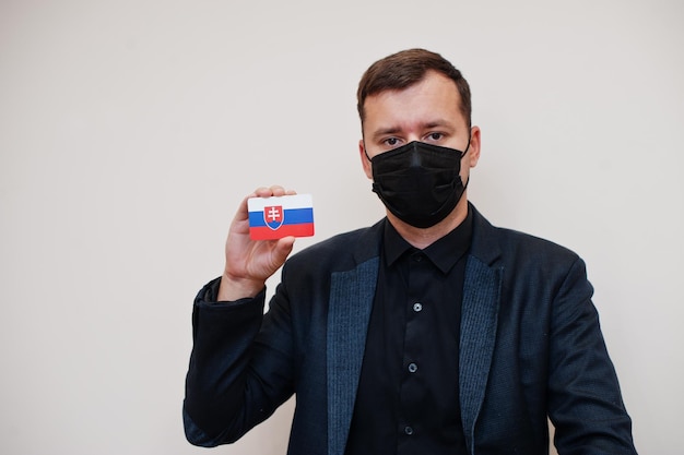 Photo european man wear black formal and protect face mask hold slovakia flag card isolated on white background europe coronavirus covid country concept