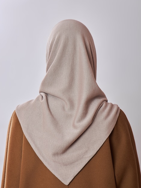 European Muslim woman with a blonde hair in a headscarf shawl dressed on her head.