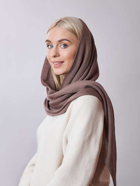 European Muslim woman with a blonde hair in a headscarf shawl dressed on her head