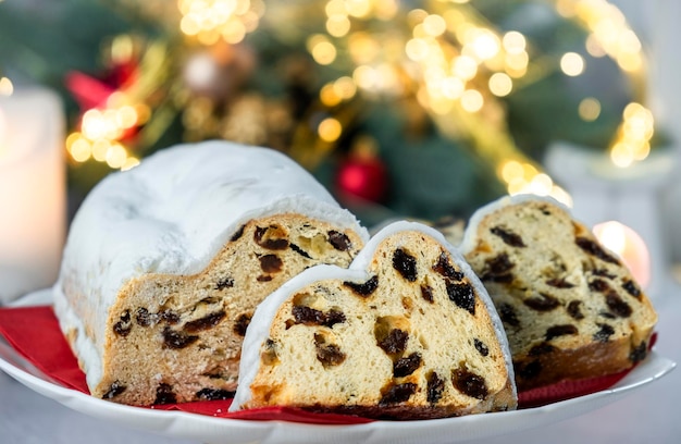 European pastry dessert with raisins nuts dried fruit and icing sugar Christmas stollen pie and bokeh lights Gluten off vegan dessert for winter holidays Merry Christmas and Happy New Year