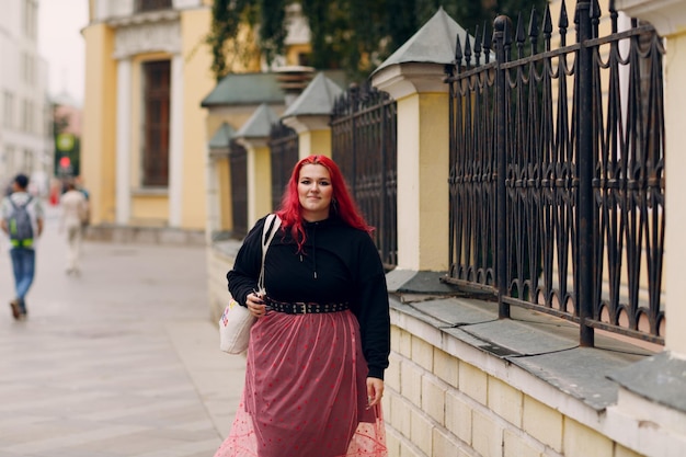 European plus size woman Young red pink haired body positive girl walk at city street outdoors