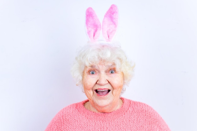 European senior pensioner with bunny ears in studio wall