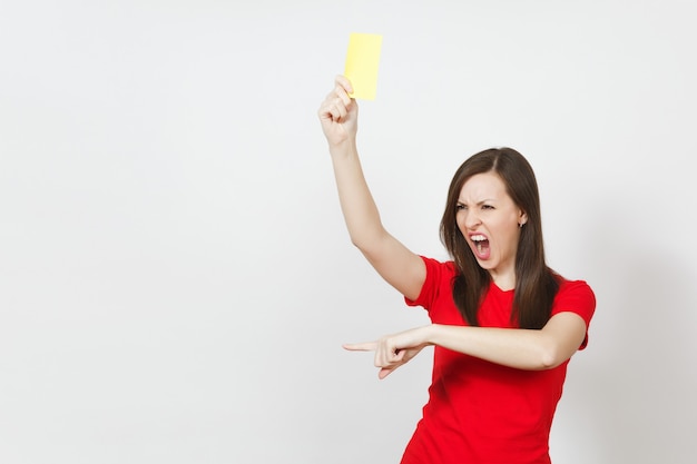 La giovane donna seria europea, arbitro di calcio in uniforme rossa mostra il cartellino giallo, propone il ritiro del giocatore dal campo isolato su priorità bassa bianca. sport, gioco, concetto di stile di vita sano.