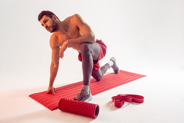 European sportsman doing exercise on fitness mat