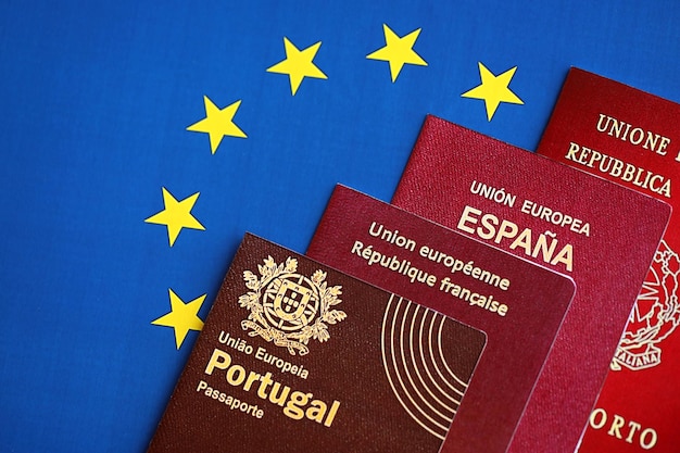 Photo european union countries passports on blue eu flag close up portugal spanish french and italian