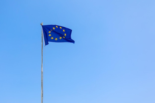 European Union EU flag is flying on blue sky background Banner place for text