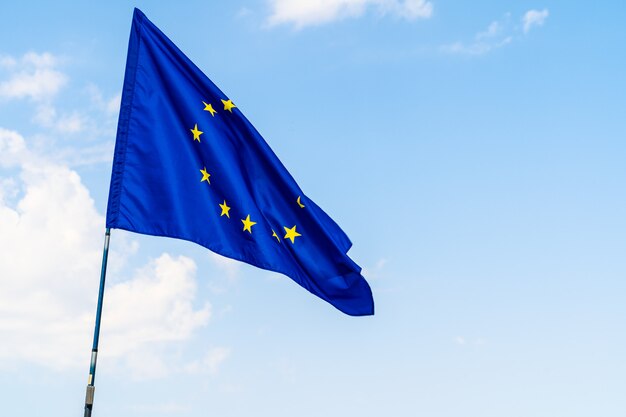 European Union flag against blue sky waving