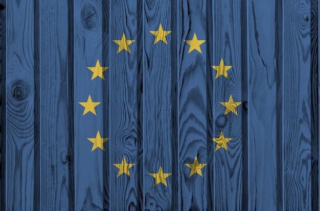 오래 된 나무 벽에 밝은 페인트 색상으로 묘사 된 유럽 연합 국기. 거친 배경에 질감 된 배너