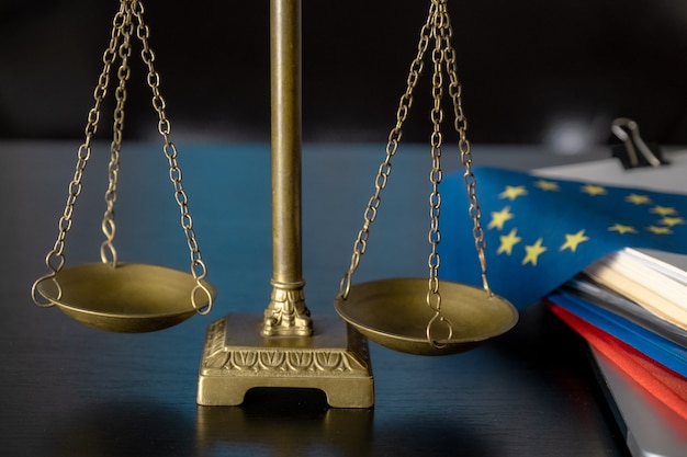 European Union Flag and Scales on the workplace of Lawyer or in the Office.