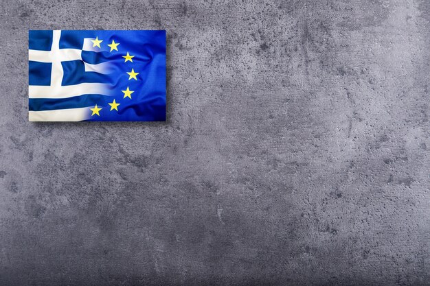 European Union and Greece flag on concrete background.