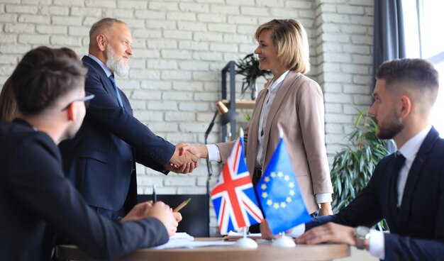 Photo european union and united kingdom leaders shaking hands on a deal agreement. brexit.