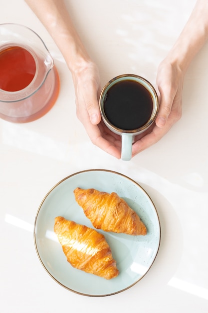 European woman brews coffee at home in her kitchen and enjoys her morning good morning