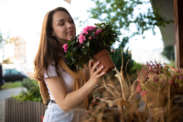 Европейская женщина выбирает цветы в качестве подарка в уличном садовом ларьке.