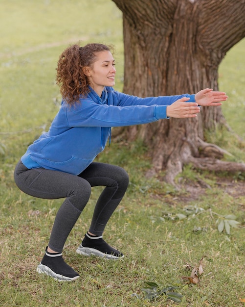 A european woman does sports in a park or a public place warmup and jogging in the fresh air