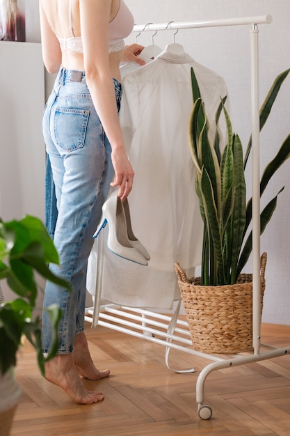 European woman at home in Wardrobe selects clothes for a party or birthday party sorting clothes