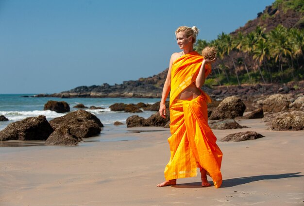 European woman in Indian dress sari by the sea