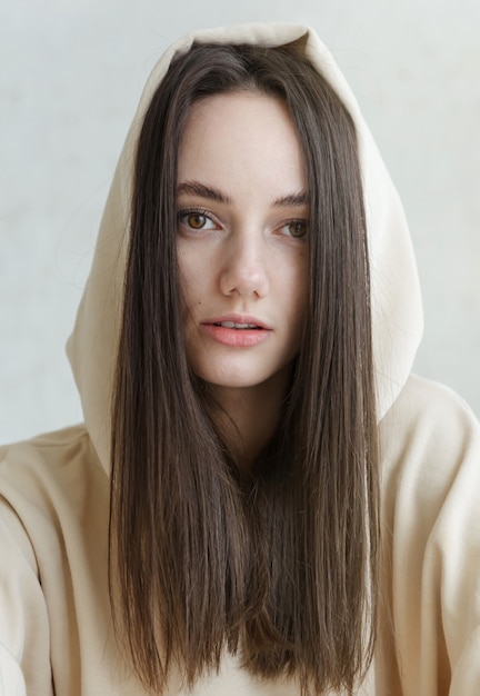 Foto viso di donna europea bruna con capelli lunghi incappucciati da vicino, ragazza russa