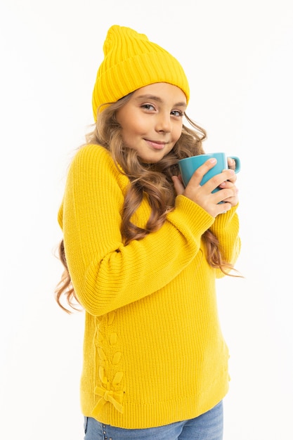 European young girl holds a mug and basks on white