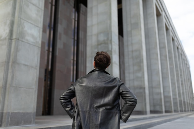 European young male looking at big dark building