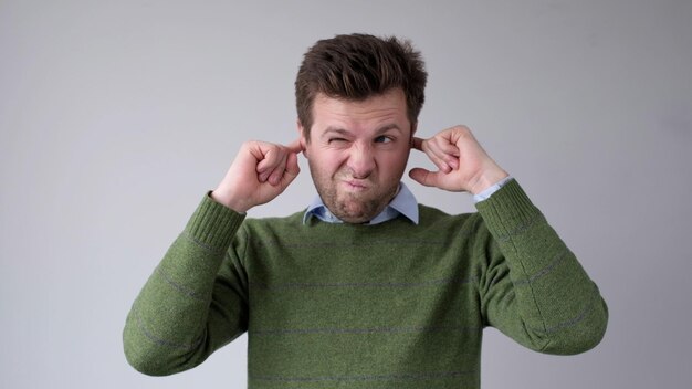 Photo the european young man covers his ears he doesnt want to hear the uncomfortable truth