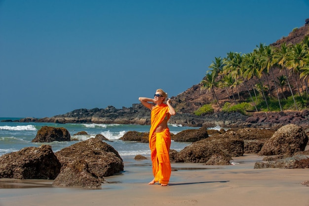 Europese vrouw in Indiase jurk sari aan zee