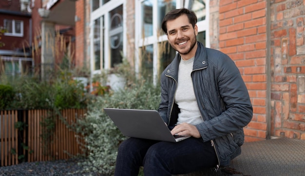 Europese zakenman die op afstand een vergadering houdt terwijl hij op een laptop op straat zit