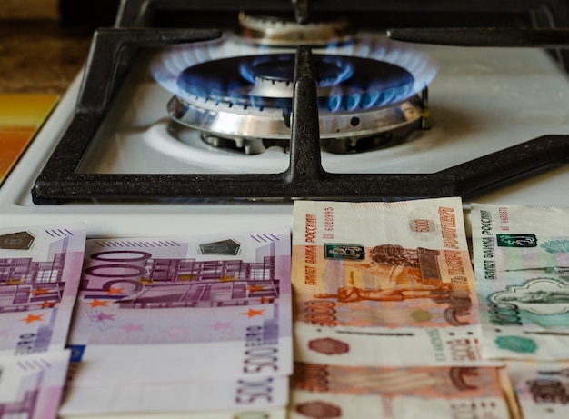 Euros and rubles near a burning gas burner. The high price of natural gas.