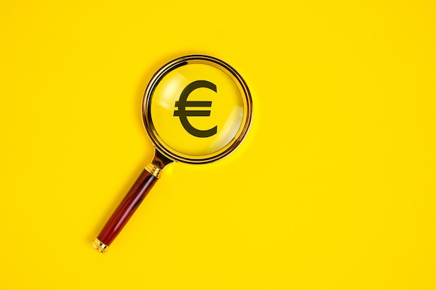 Eurosymbool onder vergrootglas op gele achtergrond