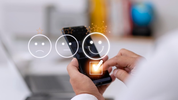 Evaluatieconcept van de klantenservice met behulp van een smartphone drukt op gezichtsemoticon die tevreden glimlacht op virtueel touchscreen