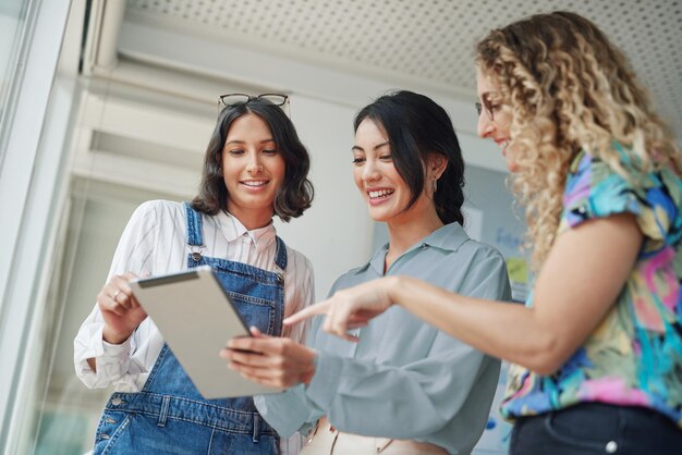 Evaluating trends and making relevant changes to suit their market Shot of a group of businesswomen using a digital tablet together in an office