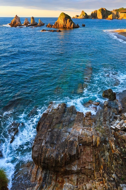 저녁 대서양 해안선 풍경입니다. 뾰족한 섬이 있는 아름다운 게이루아 해변. 아스투리아스, 스페인.