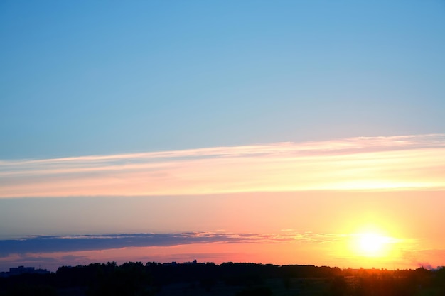 街に沈む夕方の明るい夕日