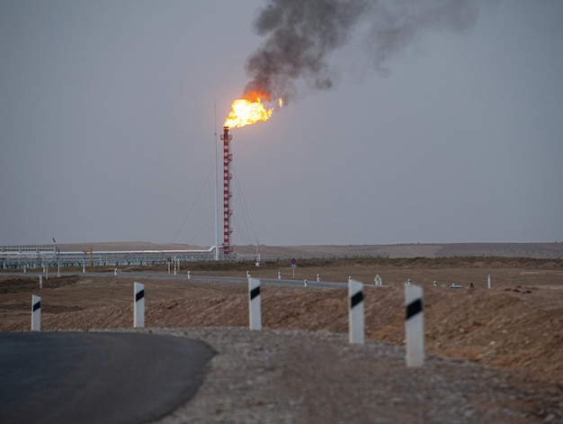 Evening highway and burning roof of the construction of the\
factory in the background